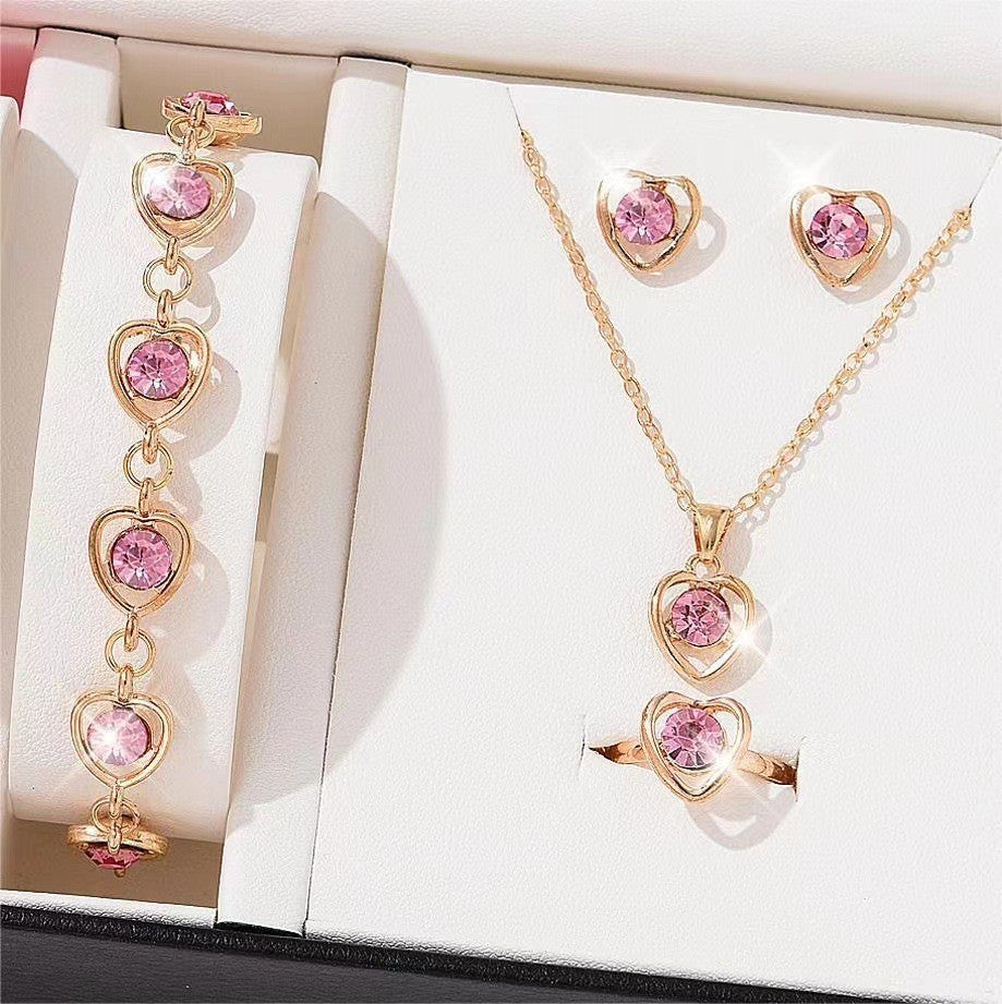 Close-up detail of heart jewelry set showing rhinestone inlays and elegant design
