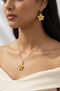 Model wearing gold flower necklace and earrings set